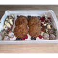 Mixed treats gift box with chocolate-covered strawberries, chocolate chip cookies and fresh berries.