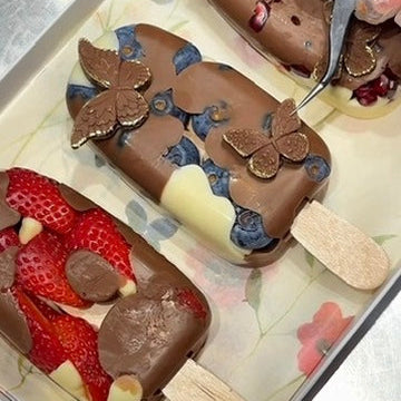 Handmade chocolate fruit pops on sticks, arranged for gifting