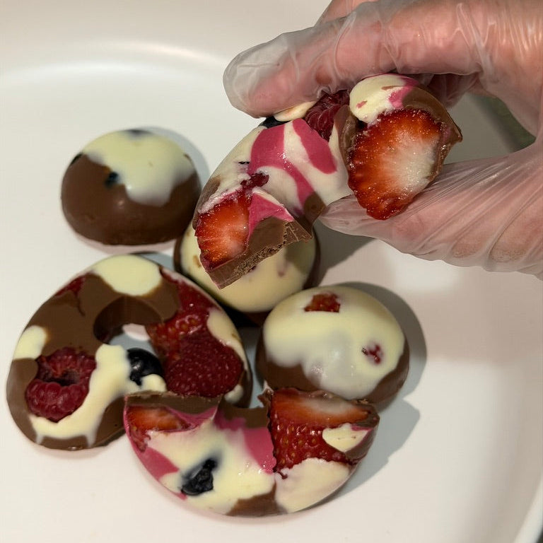 Strawberry-filled chocolate shapes arranged in a gift box.