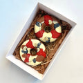 Two handcrafted chocolate-covered fruit treats in an event favour box.